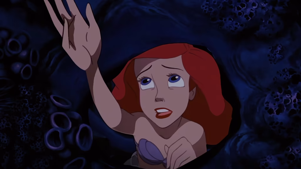 Ariel looking up towards the sky while under the sea.